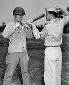 A U.S. soldier is demonstrating DDT-hand spraying equipment. DDT was used to control the spread of typhus-carrying lice.