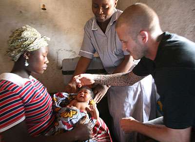 [Using celebrity and abusing kid while ignorance looks on] David Beckham visits Sierra Leone as a Unicef ambassador and gives polio drops to little Mariatsu.