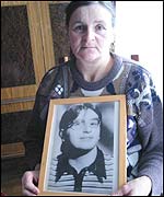 Marie Julien holds a picture of her sister, Madelein Dejust, whose body was found on the banks of the River Sereign
